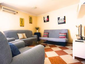 sala de estar con 2 sofás y suelo a cuadros en Casa Rural Los Mayorales II Apartamento en La Garrovilla