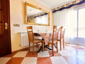 comedor con mesa, sillas y espejo en Casa Rural Los Mayorales II Apartamento en La Garrovilla