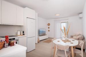 uma cozinha e sala de estar com uma mesa e um frigorífico branco em SeaView Apartment 1 em Samos