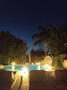 a swimming pool at night with a chair and lights at Luxury Villas Chrysa Private Pool & Spa in Nafplio