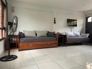a living room with two beds and a fan at Mar y Asados - Chalet hasta 19 huéspedes con dos Parrillas in Mar del Plata
