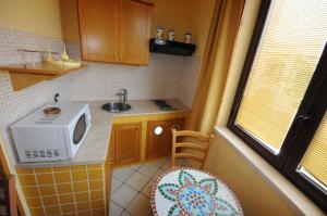 una pequeña cocina con fregadero y microondas en Residence La Torre Del Sole, en Mazara del Vallo