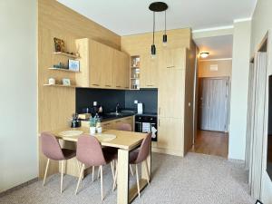 a kitchen with a wooden table and pink chairs at City view in Residences in Burgas