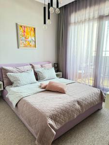 a bedroom with a large bed with a large window at City view in Residences in Burgas City