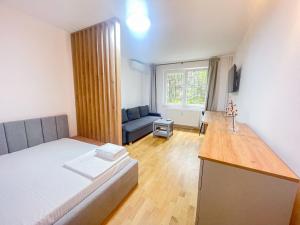 a small room with a bed and a couch at National Arena Mega Mall Mirina Studio in Bucharest