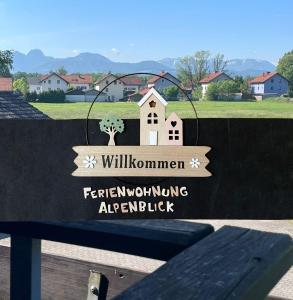 een bord bovenop een bank bij Ferienwohnung Alpenblick in Bruckmühl