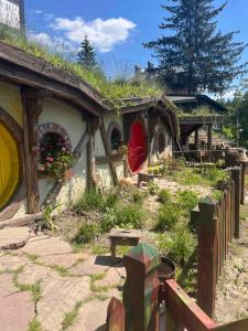 ein Haus mit einem Grasdach mit einer roten Tür in der Unterkunft Едем in Brzezhany