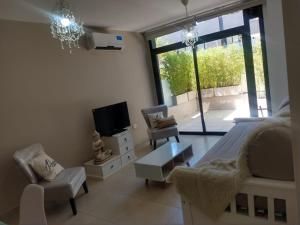 a bedroom with a bed and a tv and chairs at Zona residencial frente al lago! in Villa Carlos Paz