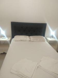 a bedroom with a white bed with two night stands at Zona residencial frente al lago! in Villa Carlos Paz