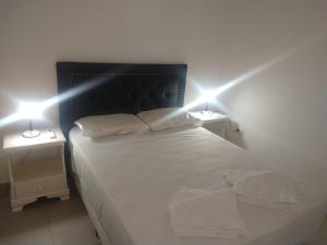 a bedroom with a bed with two lights on it at Zona residencial frente al lago! in Villa Carlos Paz +21 photos