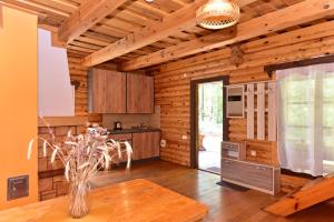 eine Küche mit Holzwänden und einem Tisch im Zimmer in der Unterkunft Sodyba Paštys in Vozgėliai