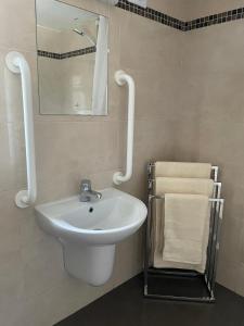 a bathroom with a sink and a mirror and towels at Castle View Cottage - Entire Home in Ballynasare +25 photos