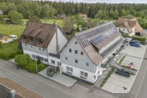 Alter Hirsch في بفالتزغرافنويلر: اطلالة جوية على منزل به لوحات شمسية على سقفه