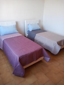 two beds sitting next to each other in a room at Casa Lino in Monserrato
