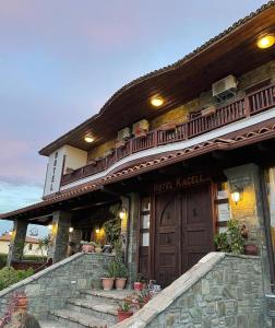 dom z dużymi drewnianymi drzwiami i schodami w obiekcie Hotel Kaceli w mieście Berat