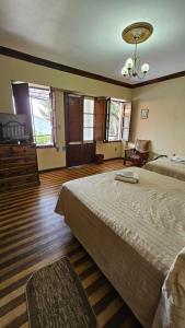 1 dormitorio con 2 camas y lámpara de araña en La Culta hostal & centro cultural en Sucre