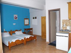a bedroom with a bed and a blue wall at Armonia Studios in Agios Georgios