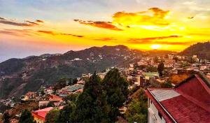 a view of a city with the sun setting at The Boho Heritage near Mall Road in Mussoorie