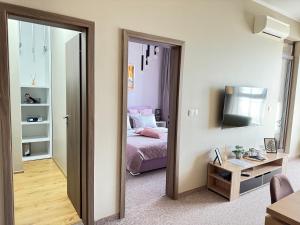 Pokój z sypialnią z łóżkiem i lustrem w obiekcie City view in Residences w Burgas