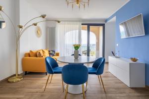 - un salon avec une table et des chaises bleues dans l'établissement Casa Vacanze Maddalena - Palazzetto sul Lago - Diamante Blu, à Marta