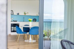 Il dispose d'un balcon et d'une cuisine avec une table et des chaises. dans l'établissement Casa Vacanze Maddalena - Palazzetto sul Lago - Diamante Blu, à Marta