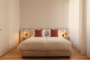 a bedroom with a large bed with red pillows at Vandoma in Porto
