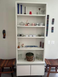 a white shelf with items on it next to two chairs at Casas aconchegantes com piscina na encantadora Praia das Cigarras in São Sebastião