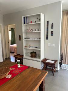 a living room with a table and a book shelf at Casas aconchegantes com piscina na encantadora Praia das Cigarras in São Sebastião