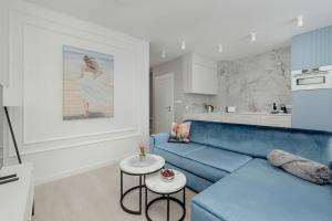 a living room with a blue couch and a table at Superior Vacation Apartment with Private Parking in Rewal
