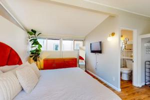 - une chambre avec un lit blanc et une télévision dans l'établissement NEW Beautiful San Diego Mid-Century Treehouse, à Spring Valley