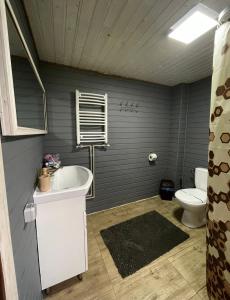 ein Badezimmer mit einer weißen Badewanne und einem WC in der Unterkunft Карпатський котедж Karpatian cottage in Worochta