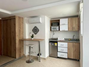 een keuken met houten kasten en een aanrechtblad bij Laureles Guest House LGH Hotel in Medellín