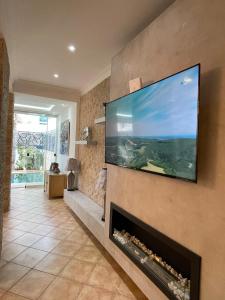 ein Wohnzimmer mit einem Flachbild-TV über einem Kamin in der Unterkunft Elegance cotiere in Tétouan