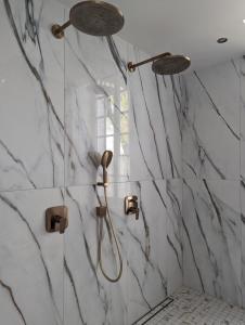y baño con ducha y paredes de mármol. en Château Haute Roche en Oudon