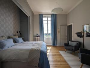 Château Haute Roche في Oudon: غرفة نوم بسرير كبير وكرسي