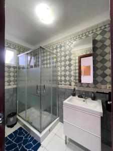 ein Bad mit einer Dusche und einem Waschbecken in der Unterkunft Elegance cotiere in Tétouan