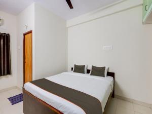 ein Schlafzimmer mit einem großen Bett in einem Zimmer in der Unterkunft OYO Flagship Valasaravakkam in Chennai