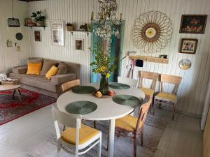 a living room with a table with chairs and a couch at Wiire old fishermans farmhouse and smoke sauna in Saulepa