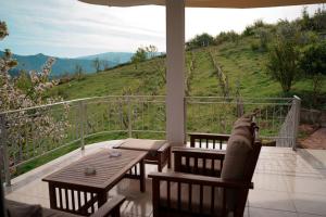 a porch with a table and chairs and a view of a hill at EliMeliVELAJ in Përmet