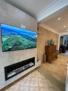 a living room with a flat screen tv above a fireplace at Villa 3 chambres piscine marinasmir in Tétouan +10 photos