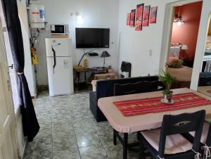 Una sala de estar con una mesa y un refrigerador. en Mitorito entre el Mar y el Bosque, en Mar del Plata