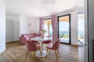 un soggiorno con tavolo, sedie e divano di Casa Vacanze Maddalena - Palazzetto sul lago - Diamante Rosa a Marta