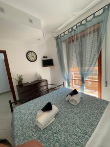 a bedroom with two towels on a bed with a window at Casa Vacanze Rosarlo in Nettuno