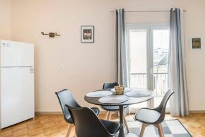 a dining room with a table and chairs and a refrigerator at Corfu Downtown in Corfu Town