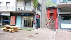 eine leere Straße mit einer Bank vor den Gebäuden in der Unterkunft Bed & Rooms , Apartments Corte Rossa in Tirano