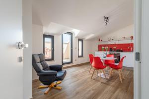 uma sala de estar com uma mesa e cadeiras vermelhas em Rosso Rubino - Mansarda Vista Lago a Marta em Marta