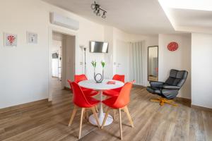 une salle à manger avec une table et des chaises rouges dans l'établissement Rosso Rubino - Mansarda Vista Lago a Marta, à Marta