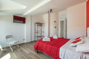 a bedroom with a red bed and a chair at Rosso Rubino - Mansarda Vista Lago a Marta in Marta