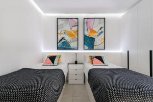 two beds sitting next to each other in a bedroom at Apartamerica 341 LujoVista Mar in Playa de las Americas