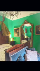 una camera verde con due letti e uno specchio di Art action room 